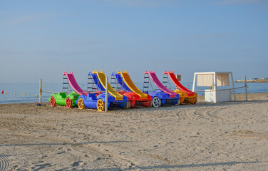 Colorful plastic beach chairs on a sandy beach in Alicante, Spain