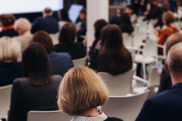 Female audience at the symposyum meeting, participants attendees in conference room hall listens to...