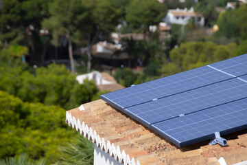 Photovoltaic solar panel mounted on a tiled roof of a bungalow in Spain.