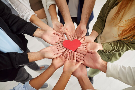 Group hand close up red heart holding together, grateful hopeful feeling pleased thankful, sincere expressing heartfelt love appreciation, gratitude honesty, team volunteering offering heart checkup