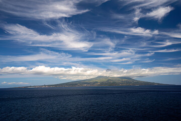 The highest cloud-covered peak of Porugalia on the Azores island of Pico in the Atlantic Ocean. View from the island Faial