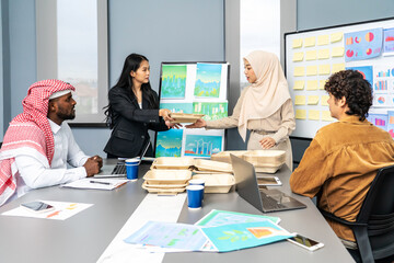 Group of multicultural business people in a discussion reusable product, implementing environmental protection, using whiteboards and presentation materials, eco-friendly packaging