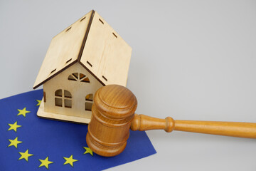 Law and real estate business in European Union. Judge gavel with wooden house model and EU flag on...