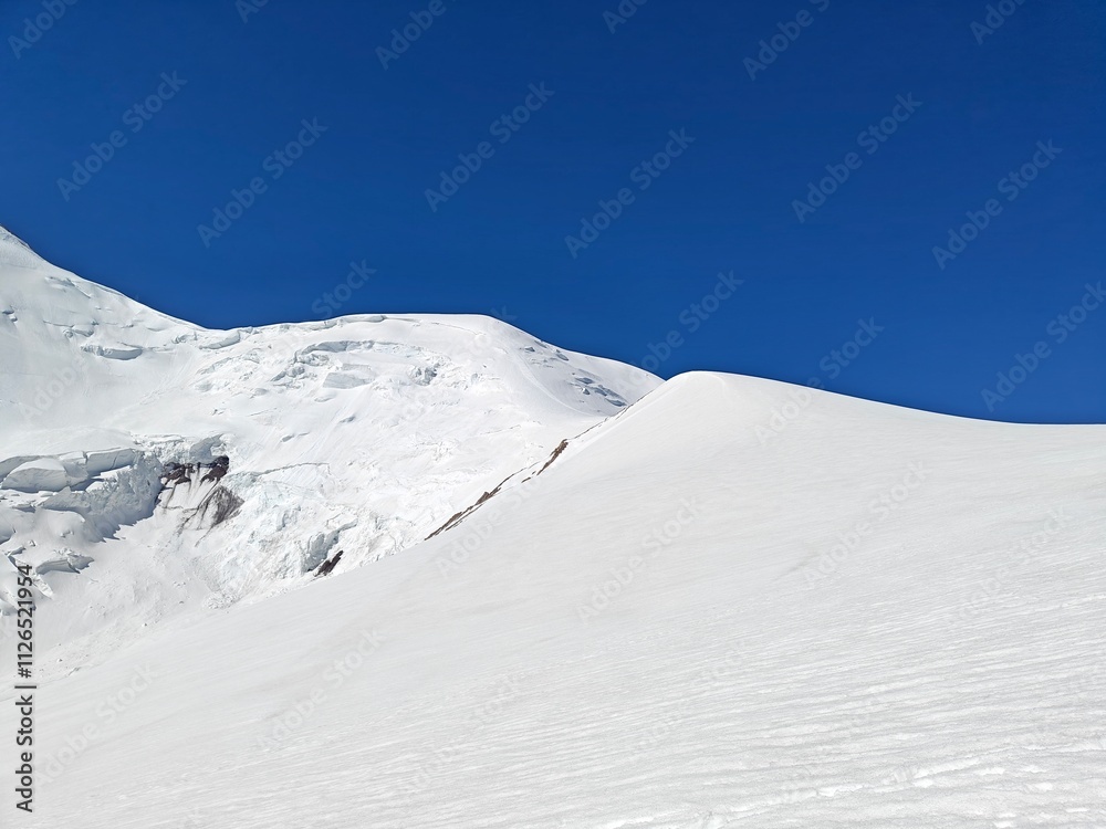 Wall mural Vast white snowfields stretch across the landscape, reflecting sunlight in a serene winter setting