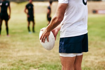 Man, hands and rugby ball for game, outdoor and challenge with exercise, wellness and fitness. Male person, athlete and recreation facility as team for match, sports and training in stadium or arena
