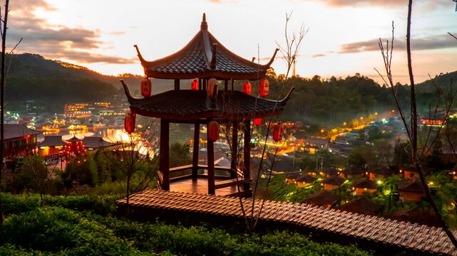 Time-lapse Night to day of the pavilion in tea plantations on the hills at Ban Ruk Thai, a Chinese Yunnan-style village amidst tea plantations. The Chinese words on the lanterns refer to place names.