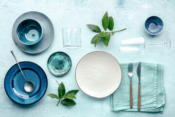 Modern tableware, overhead flat lay shot. A table setting with plates, silverware, and glasses,...