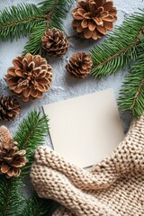 Obraz premium Cozy Winter Scene with Pine Cones, Fir Branches, Knitted Texture, and Blank Notecard