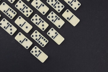 Classic domino tiles on black background, flat lay. Space for text