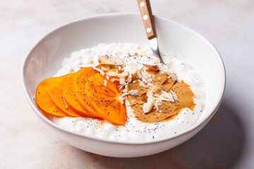Breakfast cottage cheese with peanut butter, nuts and persimmon.