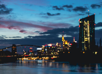 Naklejka premium Blurred Frankfurt skyline at dusk with illuminated city lights