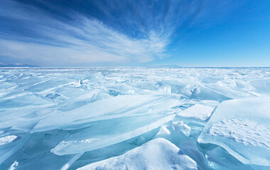 Winter natural background with fragments of blue snowy ice and heaps of pieces of ice floes on...