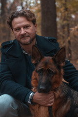 Portrait of a man with his german shepherd dog in park