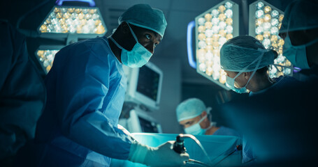 Close Up Portrait of a Black Professional Male Surgeon in a Face Mask Conducting a Surgery in an...