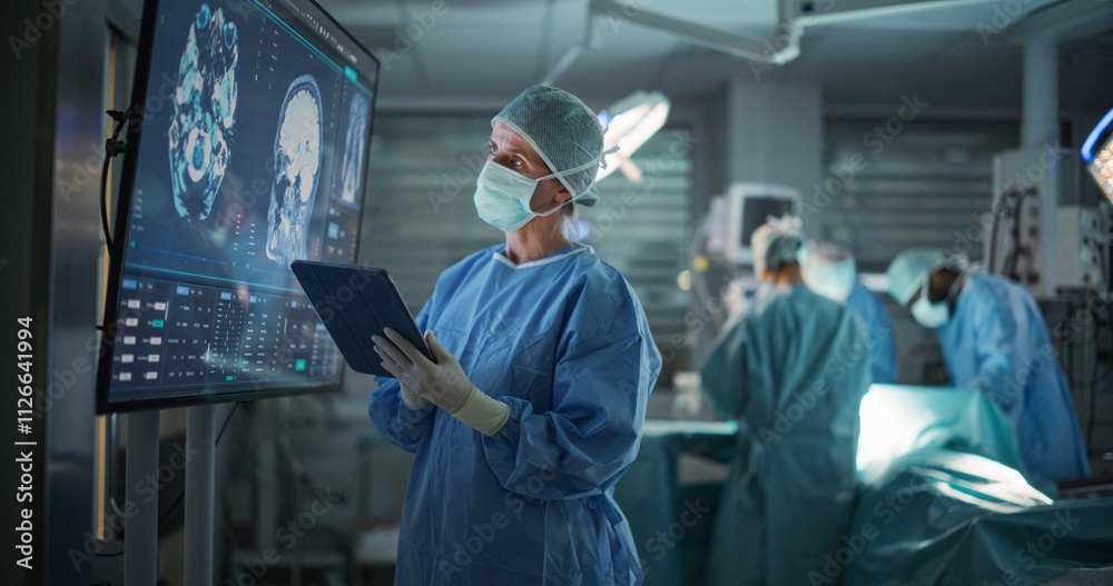 Poster lead surgeon reviews critical brain scans displayed on a monitor as well as health data on a tablet 