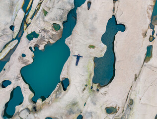 A man lying on the pothole landforms on the Yangtze River. Located in Qilin Square, Luzhou City, Sichuan Province.