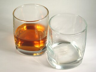 Glass of whisky and empty glass close view background