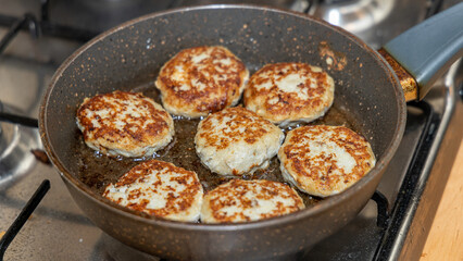 Meat burgers or cutlet-shaped patty being shallow fried in oil on a frying pan, close up. version of cutlets - kotlety.