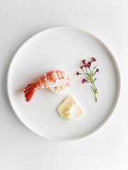 A minimalist plate featuring a shrimp, sauce, and a small flower garnish.
