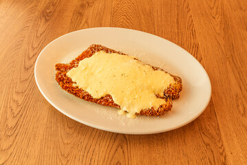 A large breaded steak with lots of sauce on top