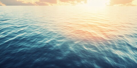 Obraz premium Aerial view of a serene sunset over tranquil water, showcasing soft hues and gentle waves. The calm water reflects a stunning warm glow, while picturesque clouds enhance the peaceful scene.