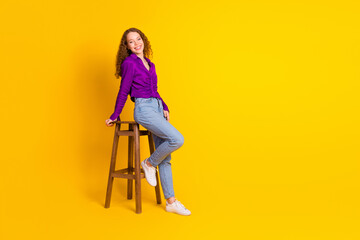 Full size photo of attractive young woman sit wooden chair dressed stylish violet clothes isolated...