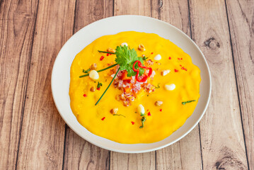 A creamy and comforting dish. Shredded chicken is bathed in a sauce made from ají amarillo, bread soaked in milk, cheese and nuts.
