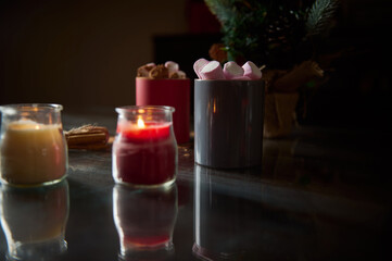 Warm candlelit ambiance with hot drink and marshmallows