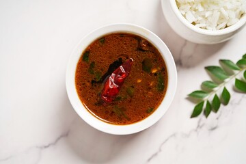 Tomato rasam served with rice, selective focus