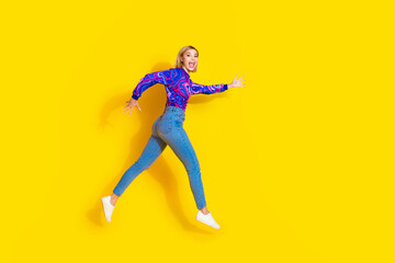 Fototapeta na wymiar Full size photo of pretty young girl run excited black friday wear trendy colorful blue outfit isolated on yellow color background