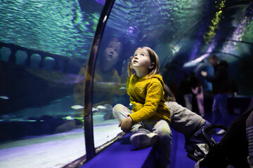 Children bonding through nature, observing aquatic life together at the aquarium.