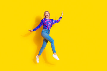 Full size photo of pretty young girl excited running hurry wear trendy colorful blue outfit isolated on yellow color background