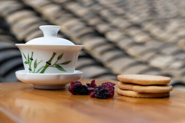 Teacups and dried blueberries and cranberries with biscuits