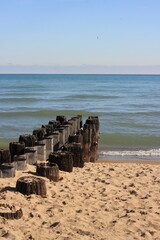 Old worn deteriorating wooden pier at the shore.