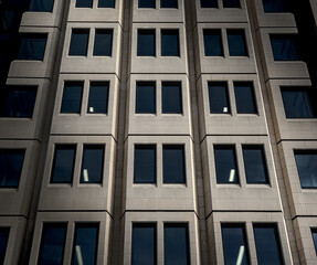 Shadows and light on a modern building facade. Front view, low angle.