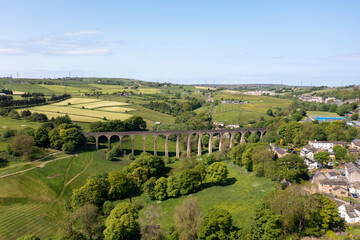 Aerial drone photo of the town of Thornton which is a village within the metropolitan borough City of Bradford in West Yorkshire, England showing the village and famous viaduct in the summer time.