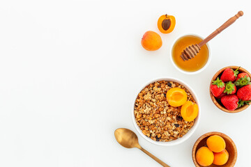 Bowl of cereal granola with strawberry and honey for breakfast, top view
