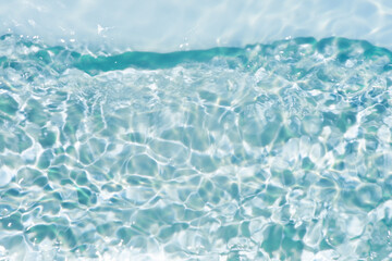 Blue water with ripples on the surface. Defocus blurred transparent blue colored clear calm water surface texture with splashes and bubbles. Water waves with shining pattern texture background.