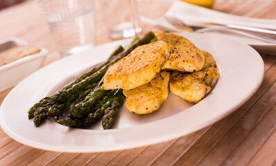 Cooked dish. Chicken nuggets with green asparagus on plate