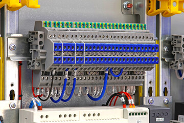 Electrical screw through terminals with connected insulated wires in an electrical switchboard.