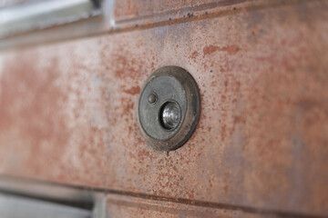 A cat's eye on a rusty iron door