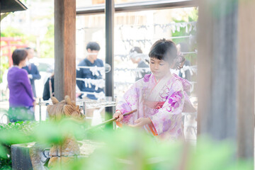 神社の手水舎で手を清める七五三の女の子