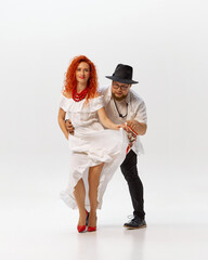 Dynamic photo of duo practices Latin dance, focusing on precision and fluidity against white studio...