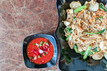 Selective focus of fried seafood vermicelli (Bihun Goreng) with spicy tomato sauce good for breakfast.