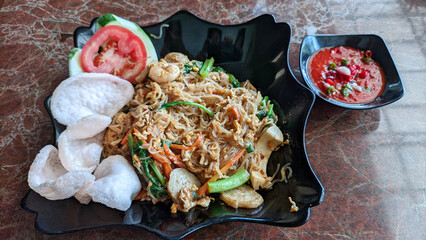 Selective focus of fried seafood vermicelli (Bihun Goreng) with spicy tomato sauce good for breakfast.