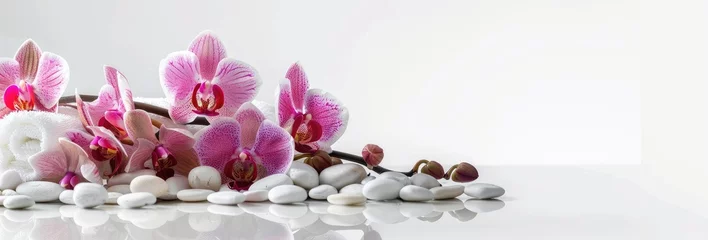 White spa towel with orchid flowers and decorative stones on white background banner for beauty treatment concept, copy space, high resolution photography
