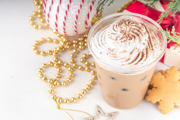 

Iced Christmas cafes menu Gingerbread vegan Oat Milk Chai Latte. Cold sweet Gingerbread coffee drink, with whipped cream and Gingerbread cookies crumbs and spices on top