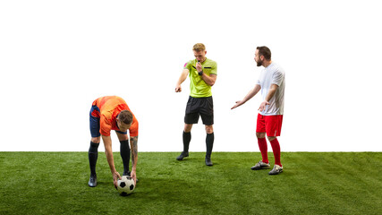 Soccer referee blowing a whistle and making gesture to signal foul while player prepares to take penalty, highlighting rule enforcement in game. Concept of sport, fair play, competition, control