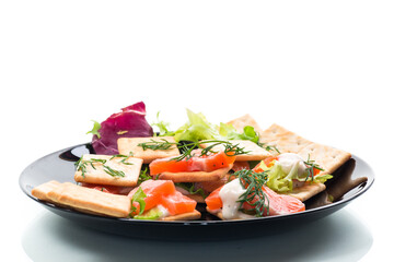 small snack canapes with crackers and lightly salted red fish Salmon, isolated on white background