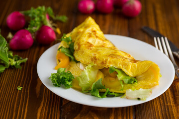 egg roll with sweet pepper and salad, on a wooden table